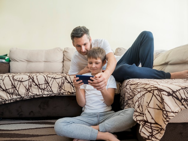 Vader en zoon spelen van videogames op mobiele telefoon