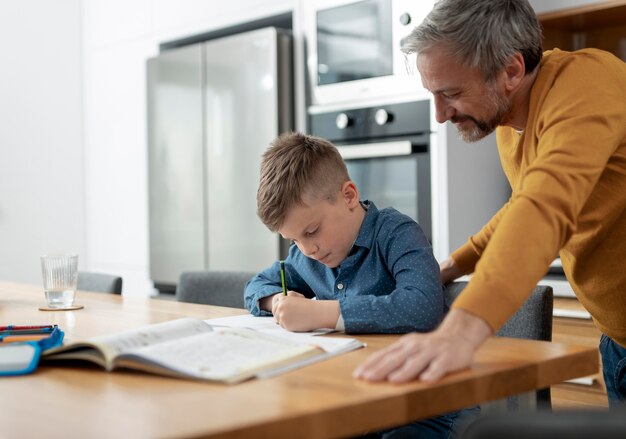 Vader helpt kind met huiswerk