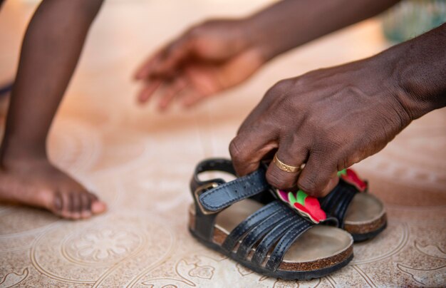 Vader helpt zijn babymeisje om haar schoenen aan te trekken