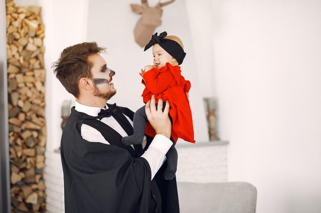 Vader met dochter in kostuums en make-up. Familie bereidt zich voor op de viering van Halloween.