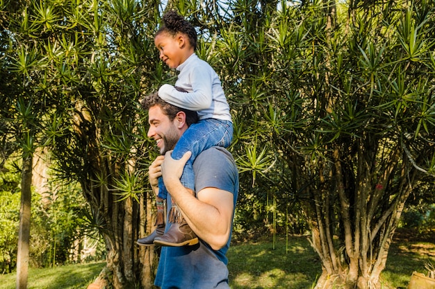 Gratis foto vader met dochter op zijn schouders