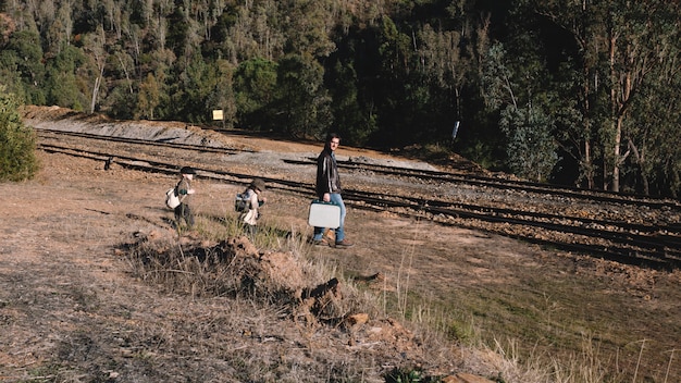 Vader met kinderen die aan spoorweg lopen