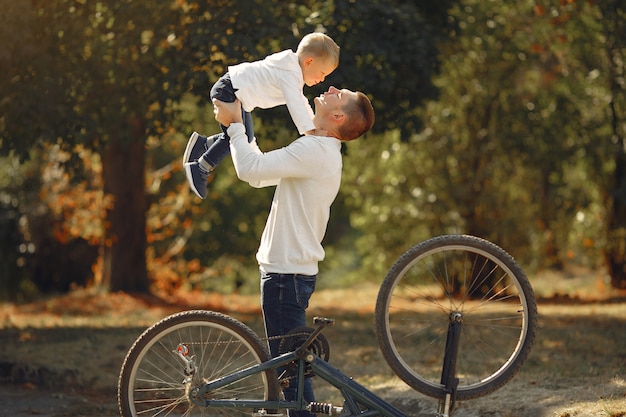 Vader met zoon repareren de fiets in een park
