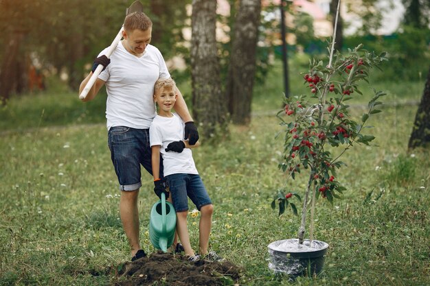 Vader met zoontje plant een boom op een erf