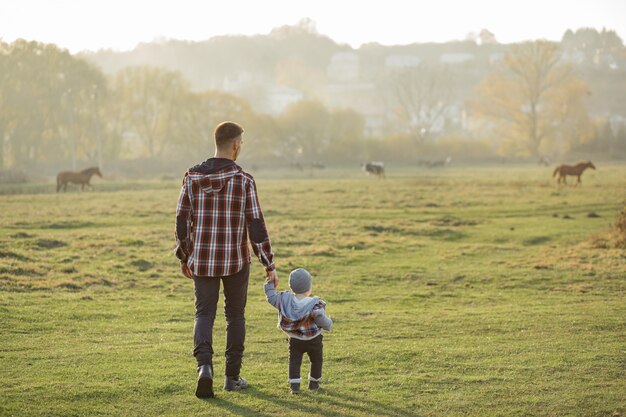 Vader met zoontje wandelen in een ochtend veld