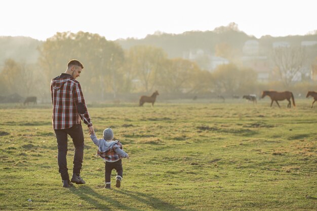 Vader met zoontje wandelen in een ochtend veld