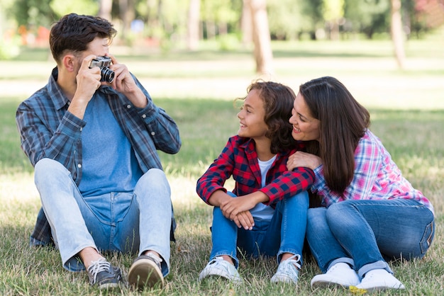 Gratis foto vader neemt een foto van zoon en moeder in het park