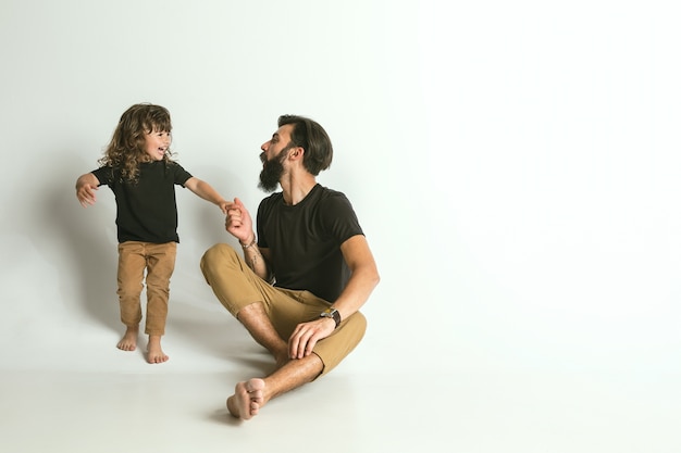 Vader spelen met jonge zoon. Jonge vader plezier met zijn kinderen in vakanties of weekend. Concept van ouderschap, kinderjaren, vaderdag en familierelatie.