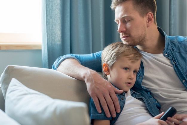 Gratis foto vaderdag vader en zoon zittend op de bank