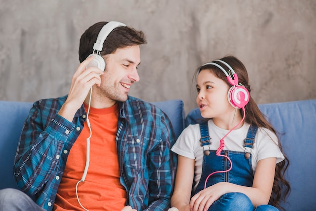 Vaders dagconcept met vader en dochter die aan muziek luisteren