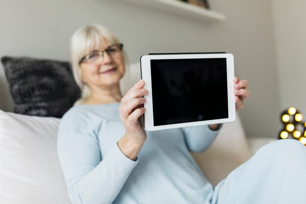 Vage vrouw die tablet toont