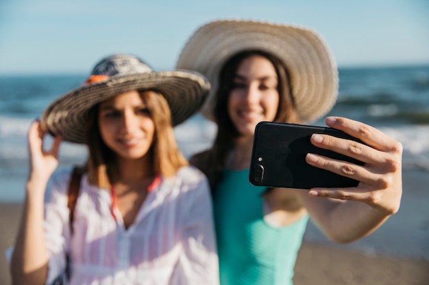 Vage vrouwen die selfie bij het strand nemen