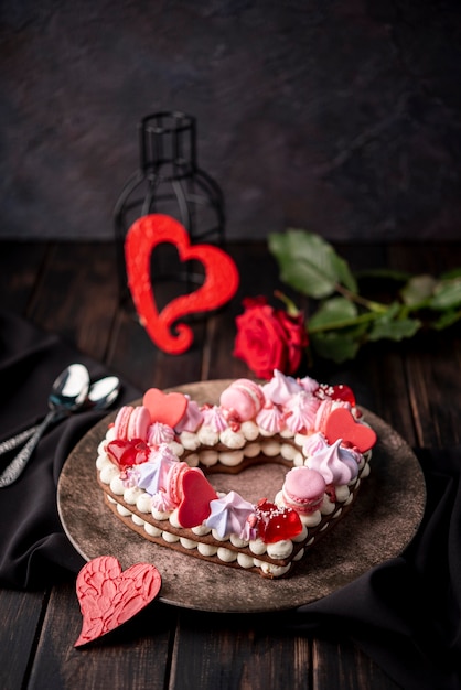 Gratis foto valentijnsdag hartvormige cake met roos en lepels