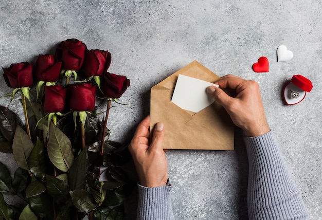 Valentijnsdag man hand met envelop liefdesbrief met wenskaart