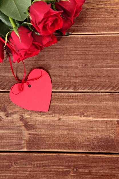 Valentine gift label en rode rozen op een houten bord