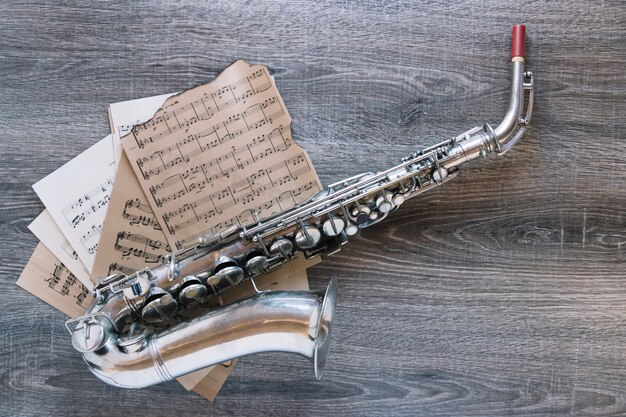 Van boven bladmuziek onder saxofoon