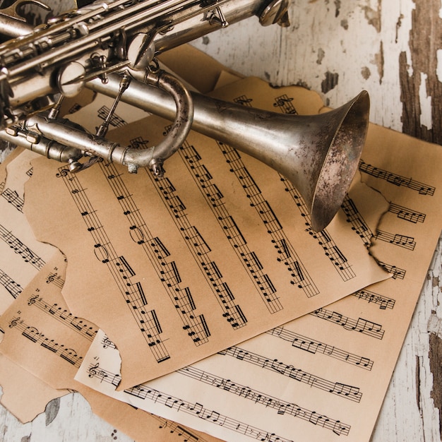 Gratis foto van boven trompet en saxofoon op bladmuziek