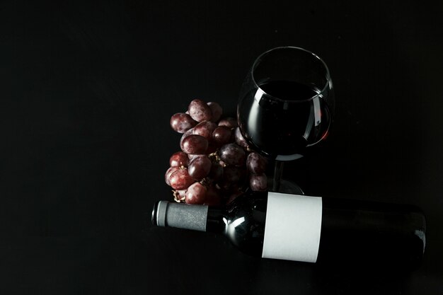 Van bovenaf druiven in de buurt van fles en wijnglas