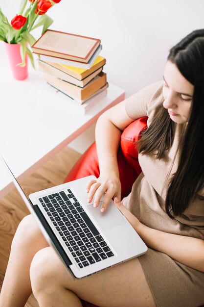 Van bovenaf vrouw met behulp van laptop