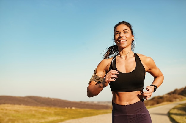 Vastberaden gespierde vrouw die rent tijdens het sporten in de natuur Ruimte kopiëren