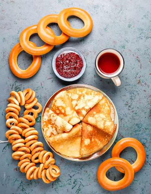 Vastenavond Maslenitsa festivalmaaltijd. Russische pannenkoekblini met frambozenjam, honing, verse room en rode kaviaar, suikerklontjes, kwark op donker