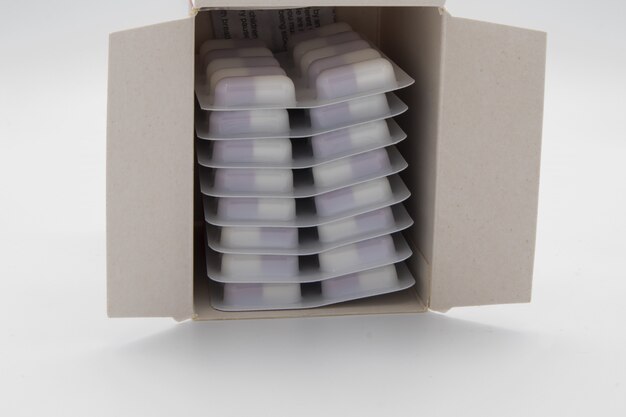 Veel medische pillen in een doos op wit