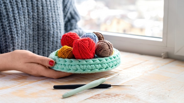 Gratis foto veelkleurige bollen garen in en bij de gebreide bank