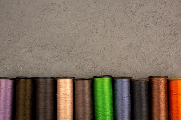 Gratis foto veelkleurige naaigaren op een grijze achtergrond