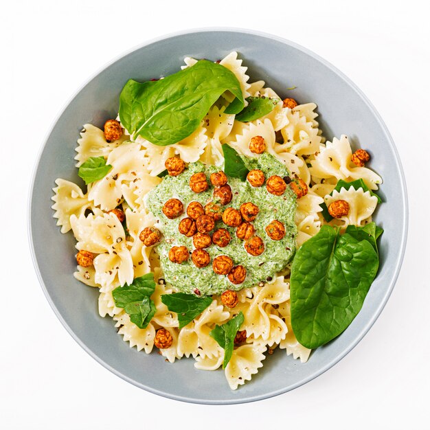 Veganistische Farfalle pasta met spinaziesaus met gebakken kikkererwten