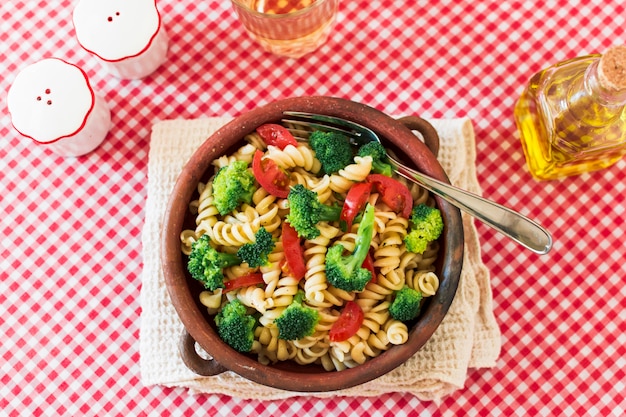 Vegetarische deegwarenfusilli met tomaat en broccoli op tafelkleed