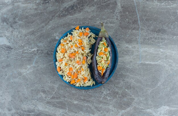 Vegetarische rijst in aubergine, op het bord, op de marmeren tafel.