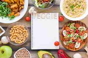 Gratis foto veggie letters op laptop omgeven door veggie eten