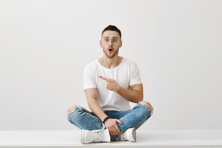 Gratis Foto verbaasd en verrast jonge kerel met bril poseren