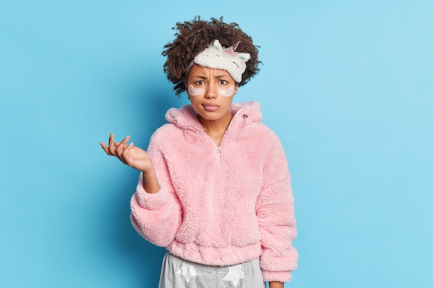 Gratis foto verbaasde afro-amerikaanse vrouw kijkt met verbijstering en steekt de handpalm in de war