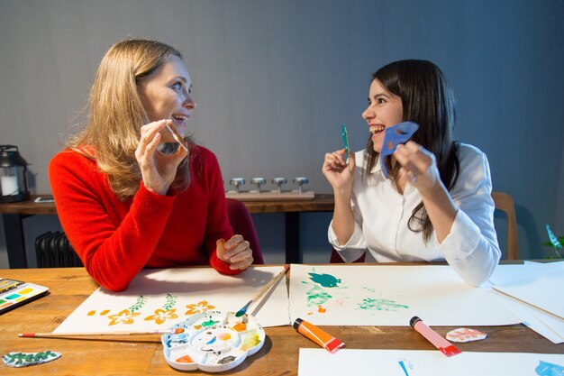 Verbaasde kunstacademiestudenten die met stencils werken