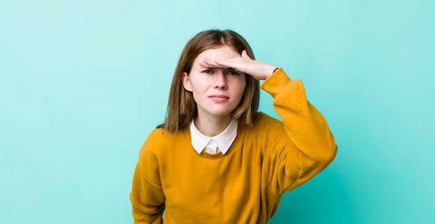 verbijsterd en verbaasd kijkend met de hand over het voorhoofd en ver weg kijkend of zoekend