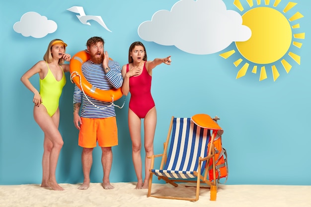 Verbijsterde groep vrienden die bij het strand stellen