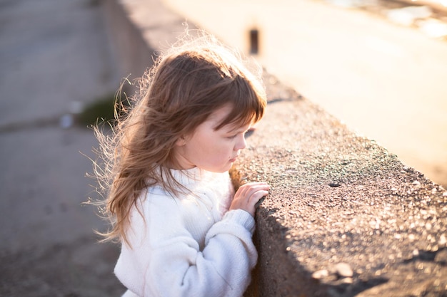 Verdrietig meisje met lange haren in de buurt van rivierkindertijd