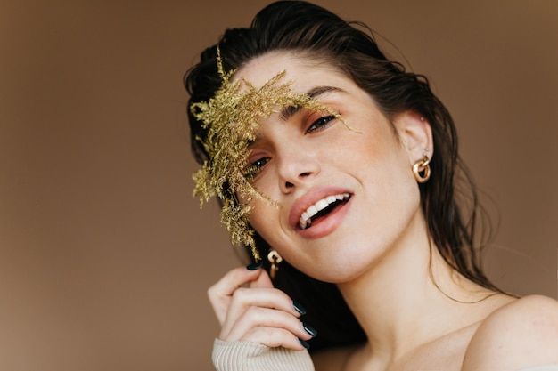 Verfijnd Kaukasisch vrouwelijk model poseren met plant en glimlachen Close-up shot van mooi Europees meisje met zwart haar