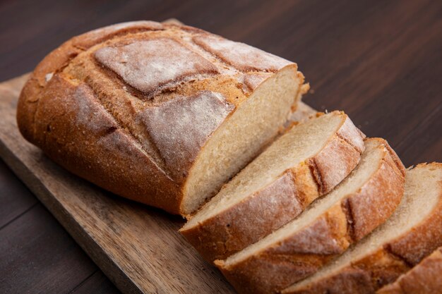 Vergrote weergave van gesneden en gesneden knapperig brood op snijplank op houten achtergrond