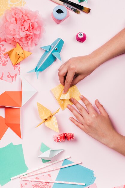 Verhoogde mening van craftswoman het maken van ambacht met origamidocument