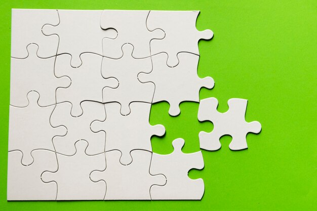 Verhoogde weergave van een kartonnen puzzel op groene achtergrond