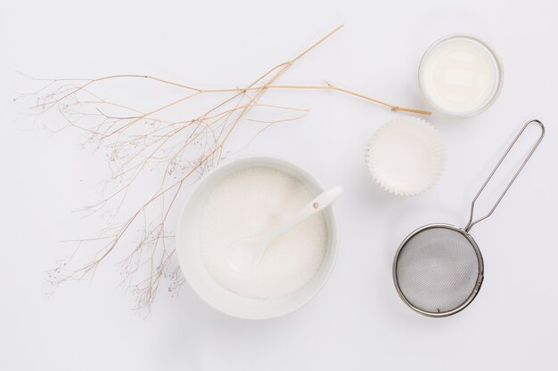 Verhoogde weergave van melk; suiker en keukengereedschap met takje