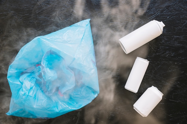 Verhoogde weergave van witte flessen en plastic zak omgeven door rook