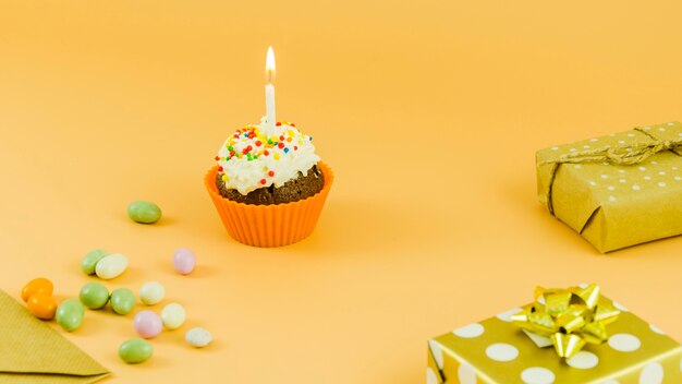 Verjaardag cupcake met kaars en geschenken