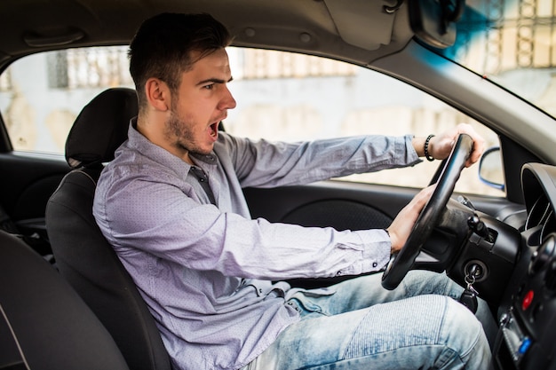 Verkeersproblemen. Aardige emotionele man die een signaal geeft tijdens het autorijden