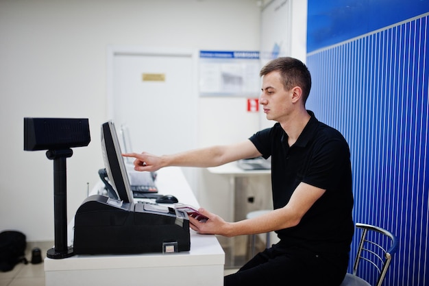 Gratis foto verkoper man mobiele telefoon professionele adviseur in technische winkel of winkel werkt bij de kassier