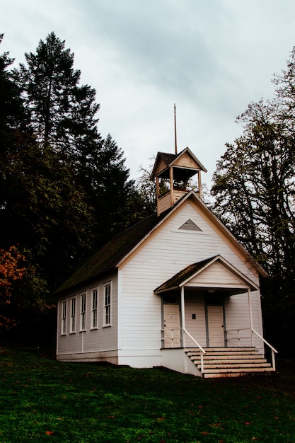 Verlaten gesloten houten kerk in een bos op het platteland