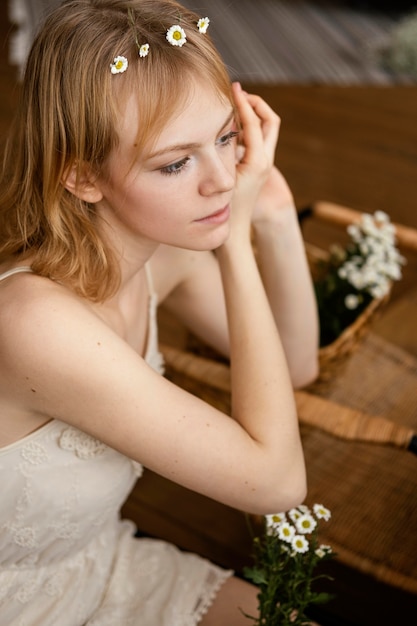 Gratis foto verleidelijke vrouw die een kroon van de lentebloemen draagt