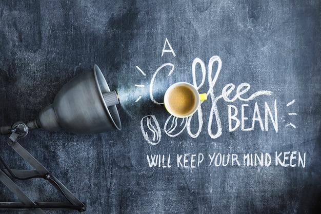 Gratis foto verlichte gloeilamp over de koffiekop en de tekst op bord